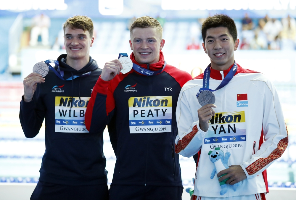 Gold medalist Adam Peaty of Britain (C), silver medalist James Wilby of Britain (L) and bronze medalist Yan Zibei of China pose during the 2019 World Championships men's 100m breaststroke medal ceremony at Nambu University Municipal Aquatics Center, Gwangju, South Korea, on Monday. — Reuters