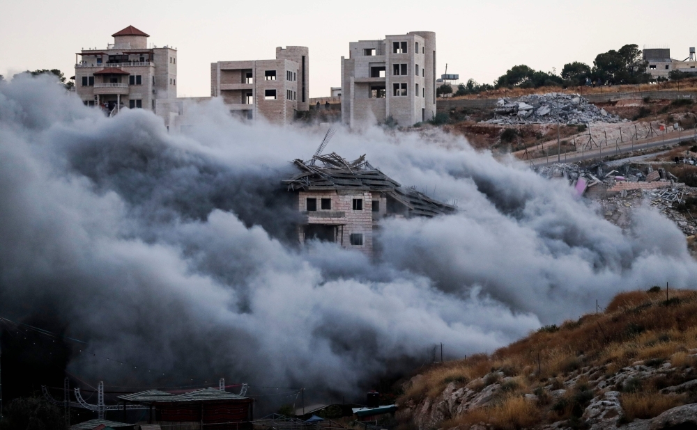 This picture taken on Monday shows the demolition of a Palestinian building which was under construction, in the the Palestinian village of Sur Baher in East Jerusalem. — AFP