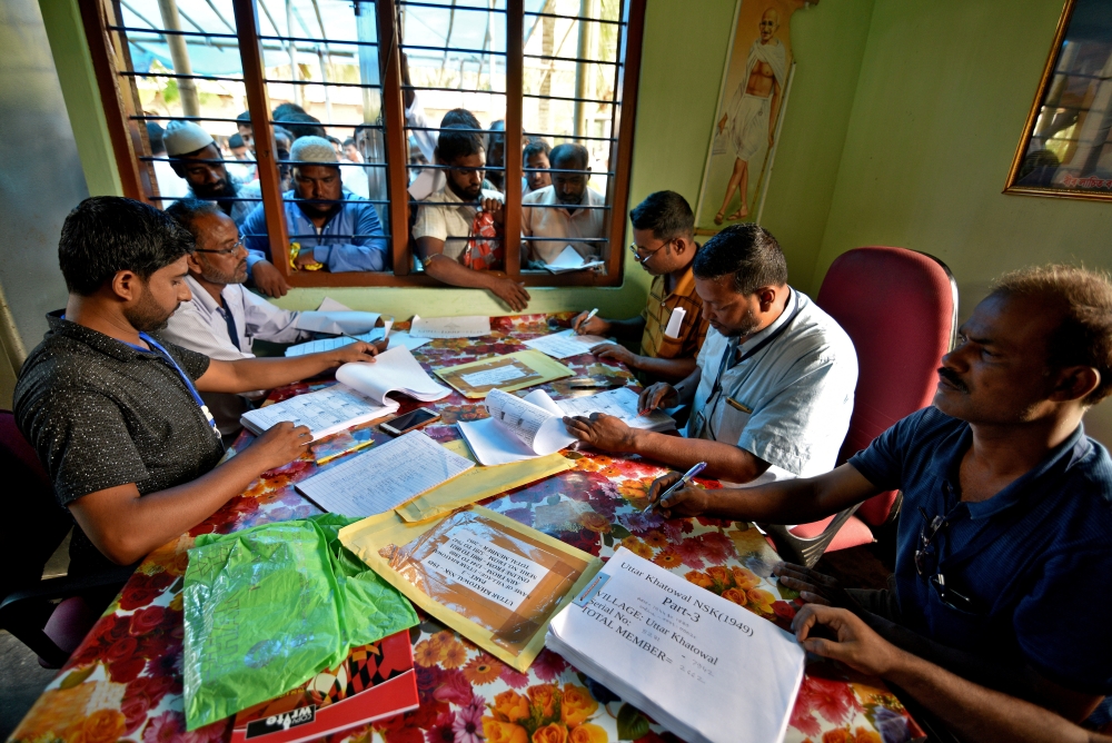 People wait to check their names on the draft list at the National Register of Citizens (NRC) center at a village in Nagaon district, Assam state, India, in this July 30, 2018 file photo. — Reuters