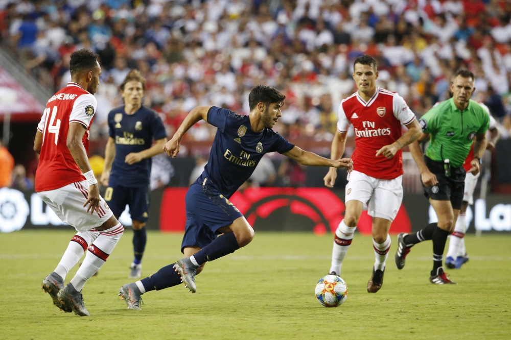 Real Madrid midfielder Marco Asensio (20) dribbles the ball past Arsenal forward Pierre-Emerick Aubameyang (14) to score a goal during the second half of a match in the International Champions Cup soccer series at FedEx Field, Landover, MD, USA, on Tuesday. — Reuters