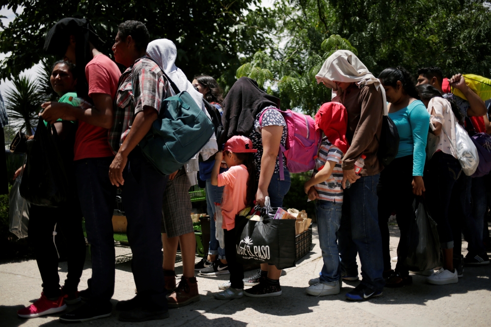 Central American migrants wait to board a bus to travel to Mexico City after they voluntarily asked to return to their countries, due to waiting too long for a court hearing for asylum seekers that returned to Mexico from the US under a new policy established by the US government, in Ciudad Juarez, Mexico, on Tuesday. — Reuters