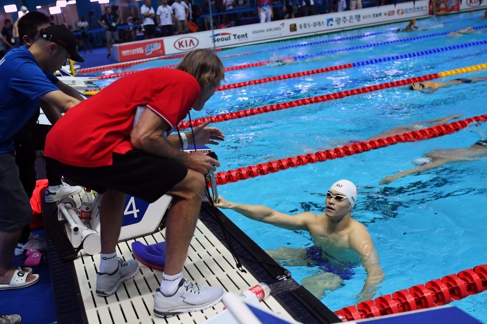 Australia's Dennis Cotterell (L) speaks to China's Sun Yang during a swimming training session at the 2019 World Championships at Nambu University Municipal Aquatics Center in Gwangju, South Korea, on Thursday. — AFP