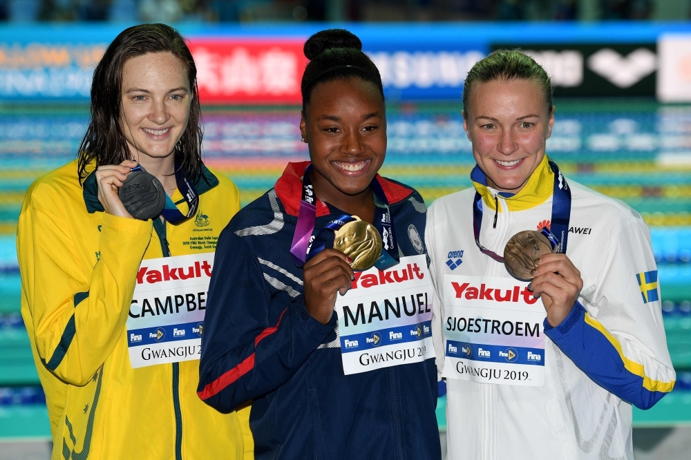 Gold medalist  USA's Simone Manuel (C), silver medalist (L) Australia's Cate Campbell (L0 and bronze medalist Sweden's Sarah Sjoestroem (R) pose after the final of the women's 100m freestyle event during the swimming competition at the 2019 World Championships at Nambu University Municipal Aquatics Center in Gwangju, South Korea, on Friday. — AFP