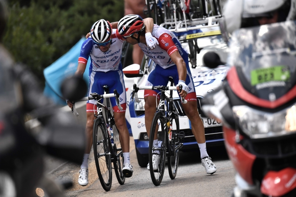 France's Thibaut Pinot (L) is comforted by teammate France's William Bonnet as he stops, forced to quit the Tour due to pain in his left leg during the nineteenth stage of the 106th edition of the Tour de France cycling race between Saint-Jean-de-Maurienne and Tignes, in Tignes, on Friday. — AFP