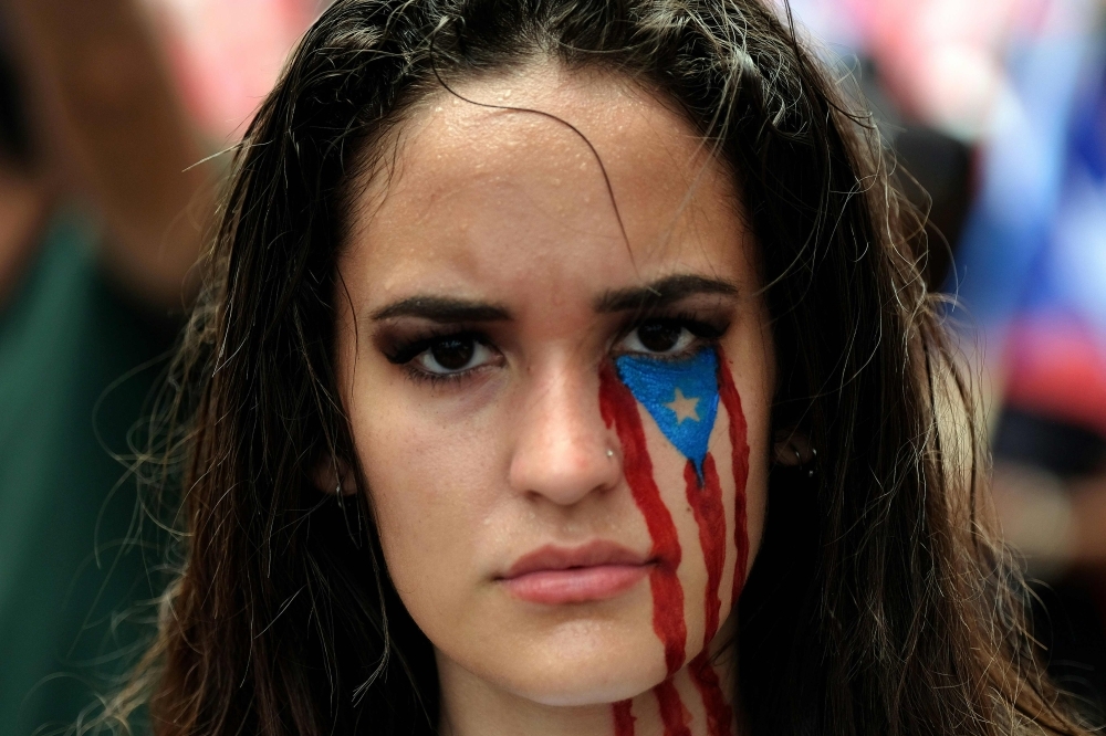 Demonstrators participate in a march the day after the governor of Puerto Rico, Ricardo Rossello resigned from his charge in San Juan, on Thursday. — AFP