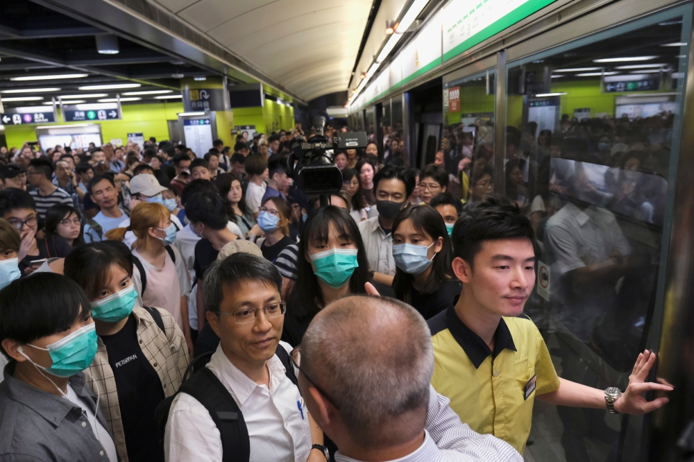 Anti-extradition bill demonstrators block a Mass Transit Railway (MTR) train in Hong Kong on Tuesday. -Reuters photo