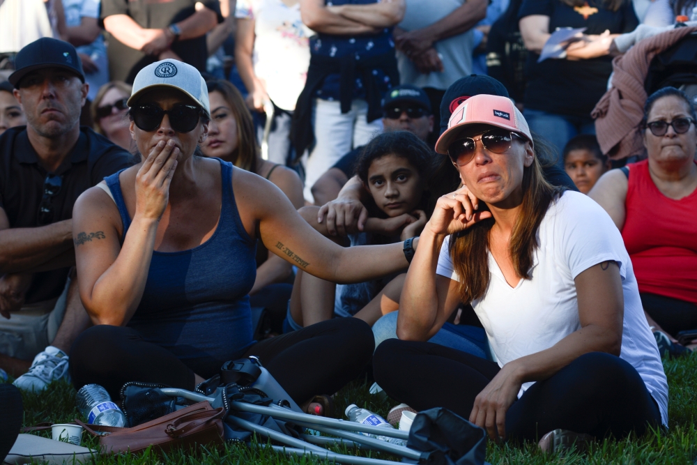 Jaclyn Ceballos and Nikki Dequin listen to speakers outside of Gilroy City Hall during a vigil for victims of the mass shooting at the Gilroy Garlic Festival a day earlier, in Gilroy, California, on Monday. -Reuters photo
