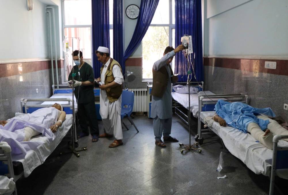 Afghan men receive treatment at a hospital after a bus was hit by a roadside bomb in Herat province, western Afghanistan on Wednesday. -Reuters photo