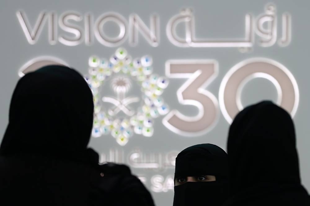 Saudi women stand next to the Saudi pavilion (vision 2030) at the Gitex 2018 exhibition at the Dubai World Trade Center in Dubai on October 2018. AFP