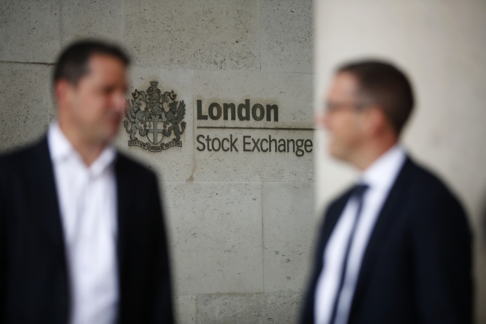Commuters walk past the London Stock Exchange in the City of London in this Aug. 9, 2017 file photo. — AFP