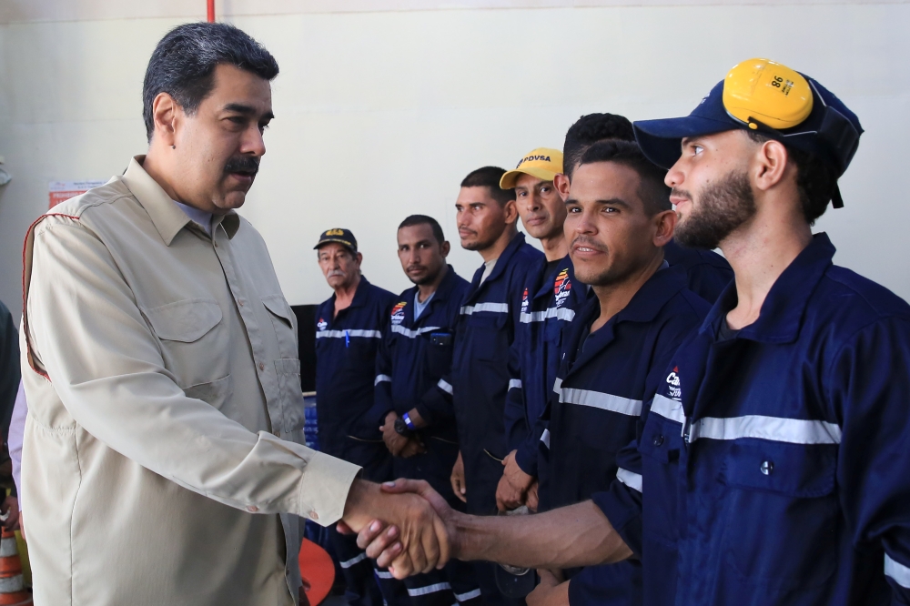 Venezuela's President Nicolas Maduro shakes hands with workers as he visits a ferry during his meeting with representatives of the water transport sector in La Guaira, Venezuela on Friday. -Reuters photo