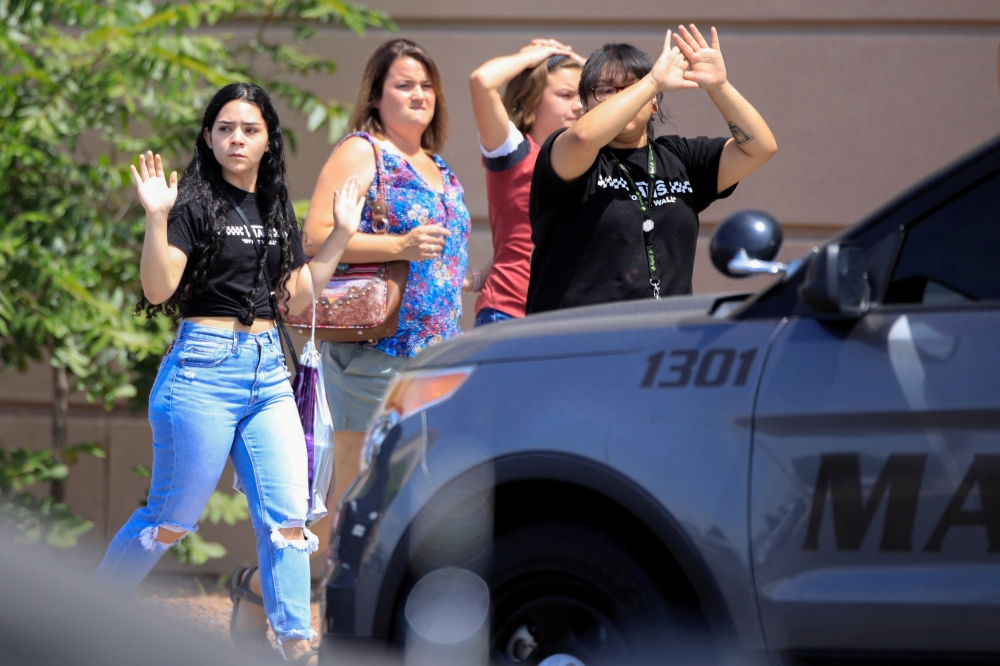  Shoppers exit with their hands up at the nearby Cielo Vista Mall after a mass shooting at a Walmart in El Paso, Texas, on Saturday. -Reuters