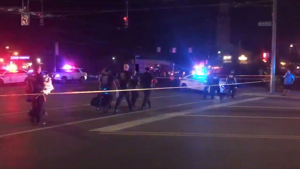 This videograb taken from the Twitter account of Derek Myers shows police officers walking behind police cordon following a mass shooting in the popular hotel and nightlife Oregon district in Dayton, Ohio, on Sunday. — AFP 