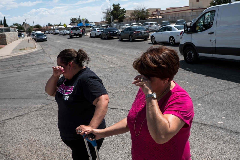 This videograb taken from the Twitter account of Derek Myers shows police officers walking behind police cordon following a mass shooting in the popular hotel and nightlife Oregon district in Dayton, Ohio, on Sunday. — AFP 
