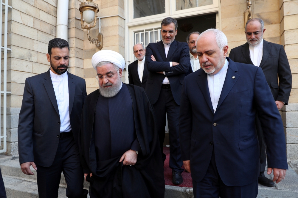 Iranian President Hassan Rouhani, left, walks with Iran's Foreign Minister Mohammad Javad Zarif after a meeting in Tehran on Tuesday. — Reuters