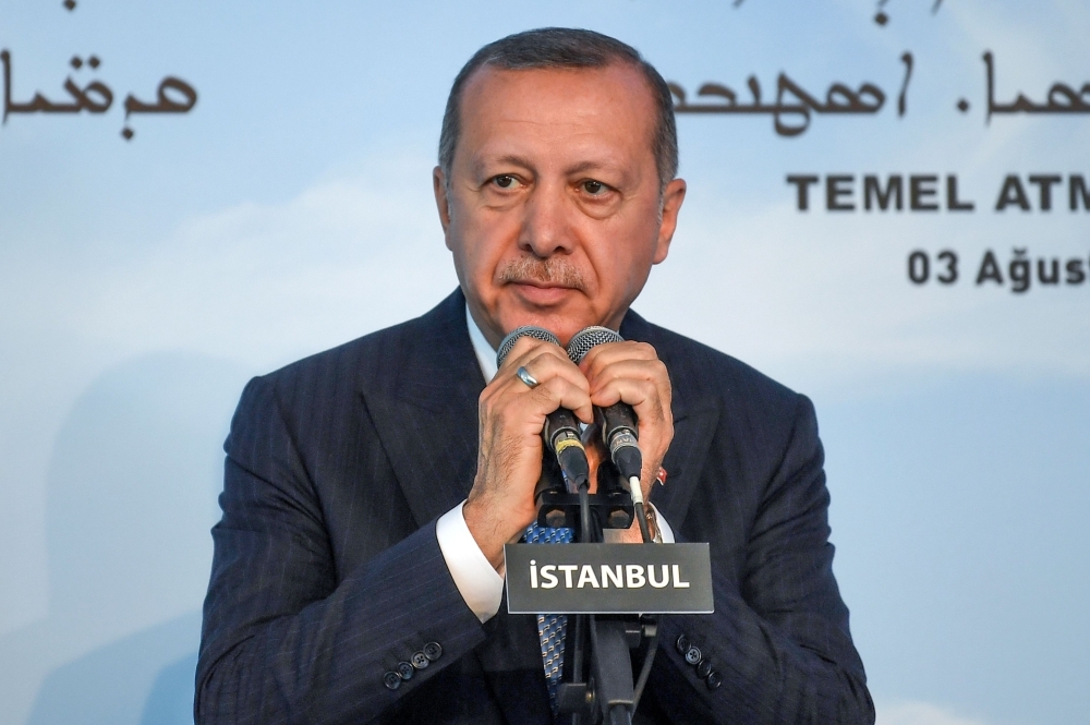 Turkish President Recep Tayyip Erdogan holds the microphones as he delivers a speech during the first stone ceremony of Turkey's first church in the modern history of the modern Republic in Istanbul's Yesilkoy district, in this Aug. 3, 2019 file photo. — AFP