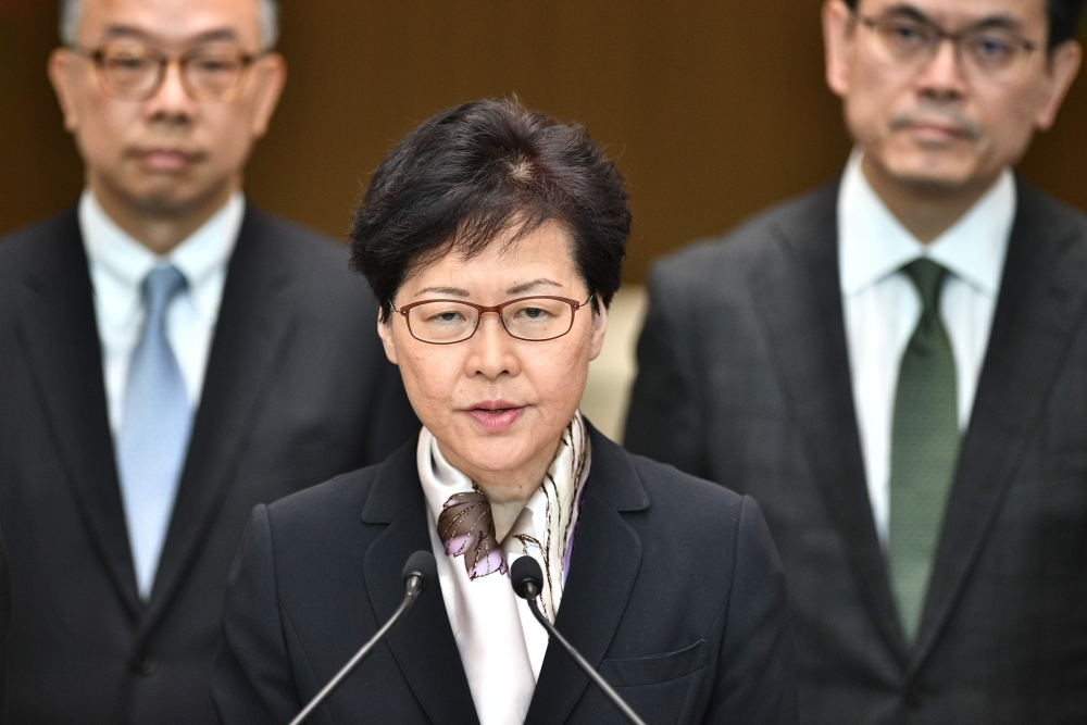 Hong Kong Chief Executive Carrie Lam, center, speaks during a press conference in Hong Kong on Monday. — AFP