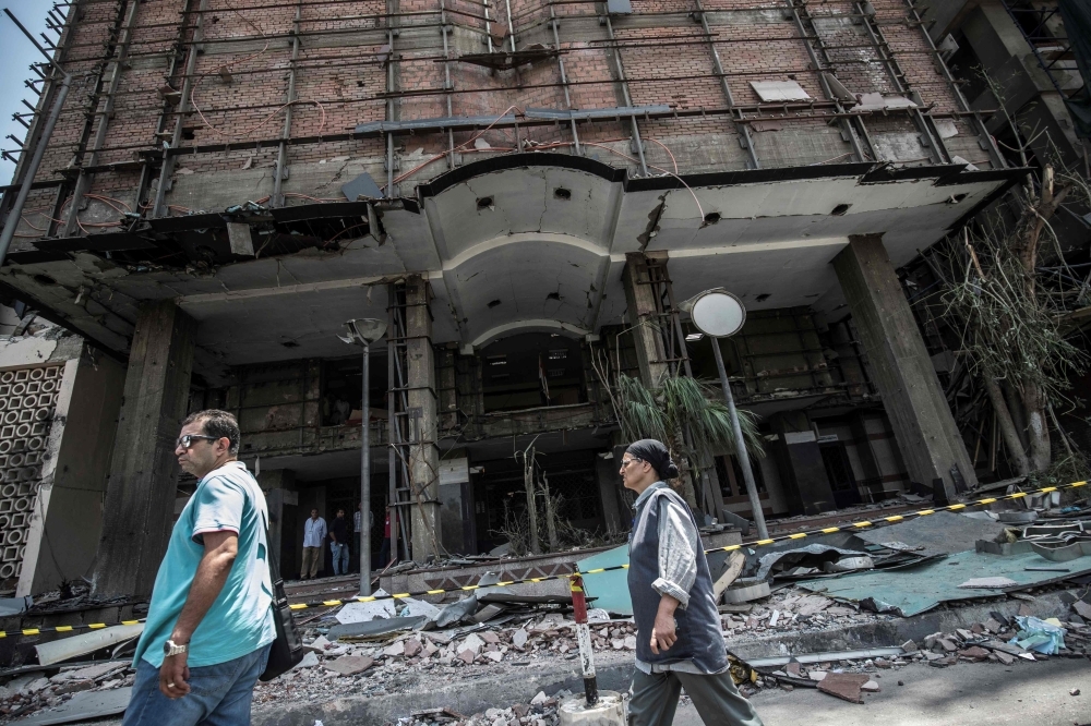 Egyptians walk outside the National Cancer Institute in the capital Cairo on Aug. 5, 2019, where an accident took place just before midnight the previous day. — AFP