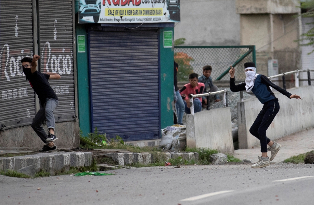 Kashmiri residents throw stones towards Indian security forces during restrictions after the scrapping of the special constitutional status for Kashmir by the government, in Srinagar, on Saturday. -Reuters