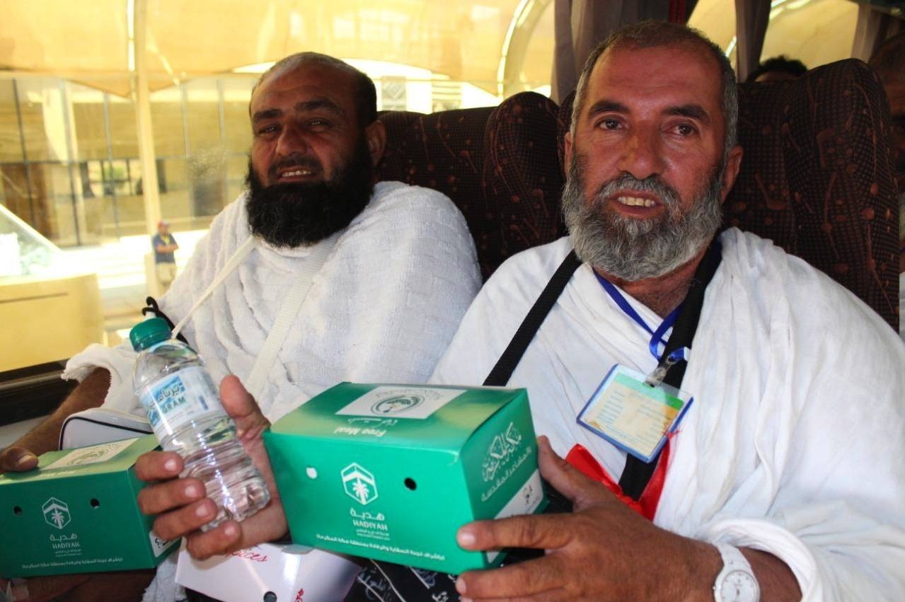 Pilgrims receive packages of ready meals and water bottles. — SPA