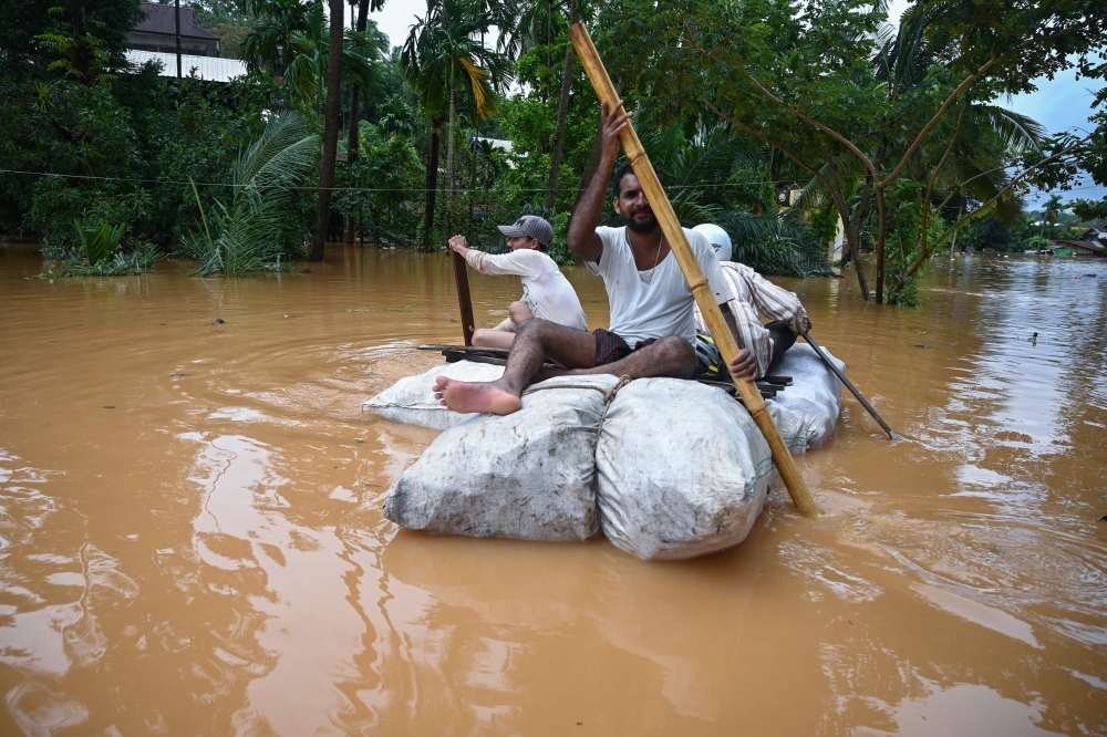 Residents use improvised materials as floodwaters submerged areas of Ye township in Mon State, Myanmar, on Sunday. — AFP
