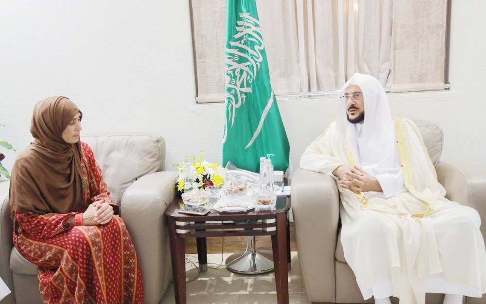 Minister of Islamic Affairs, Call and Guidance Abdullatif Al-Asheikh speaks with Naila Hassan, the director of the police in Auckland. — Okaz