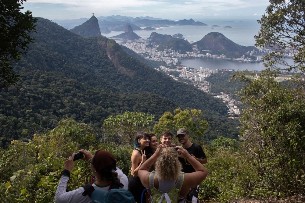 People take photos as they walk along a hiking trail -part of a projected 8,000-kilometer trail across Brazil, which will be one of the losgest in the Americas- in Rio de Janeiro, Brazil, on July 21, 2019.  -AFP