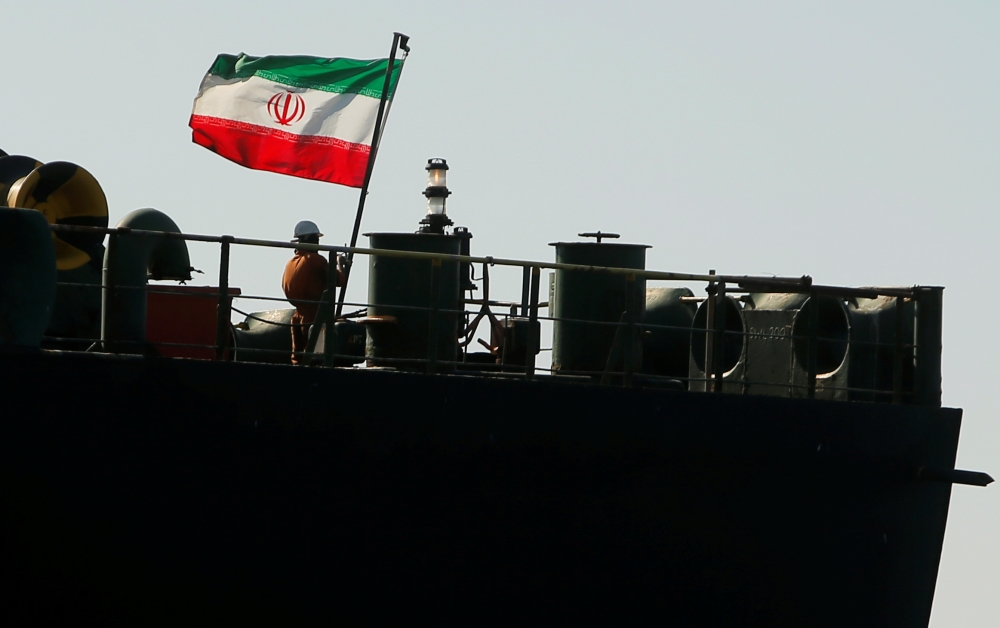 A crew member raises the Iranian flag on Iranian oil tanker Adrian Darya 1, previously named Grace 1, as it sits anchored after the Supreme Court of the British territory lifted its detention order, in the Strait of Gibraltar, Spain, on Sunday. -Reuters