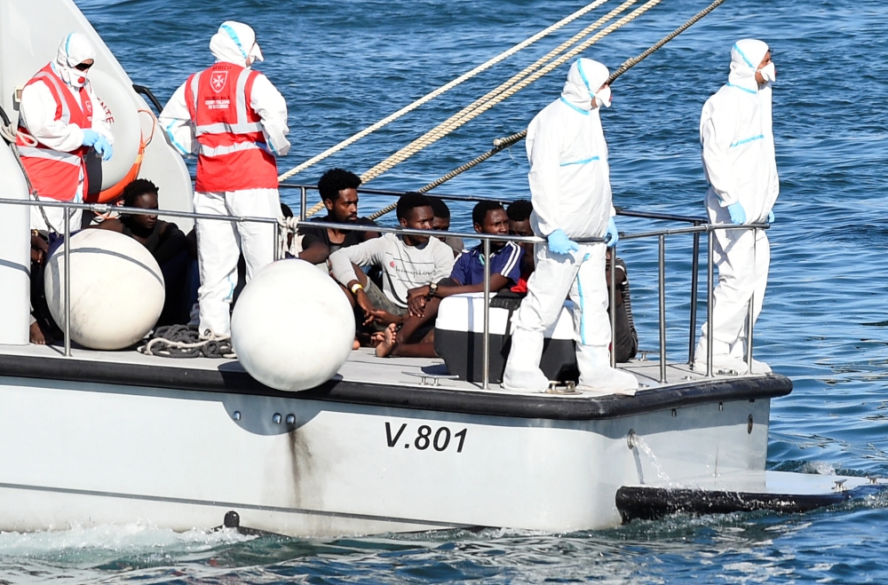Minors who were among migrants stranded on the Spanish migrant rescue ship Open Arms are pictured before disembarking from an Italian Finance Police boat, in Lampedusa, Italy on Sunday. -Reuters