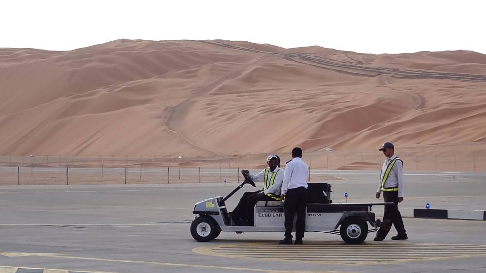 In this file photo, Aramco staff members stand on the tarmac at the Saudi Aramco airport surrounded by sand dunes by the Shaybah oilfield, some 800 km southeast of the eastern oil center of Dhahran. — AFP