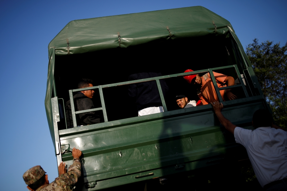 Venezuelan migrants get on military trucks to get a free ride from the Ecuadorian-Peruvian border service to Tumbes, after processing their documents, on the outskirts of Tumbes, Peru June 15, 2019. -Reuters
