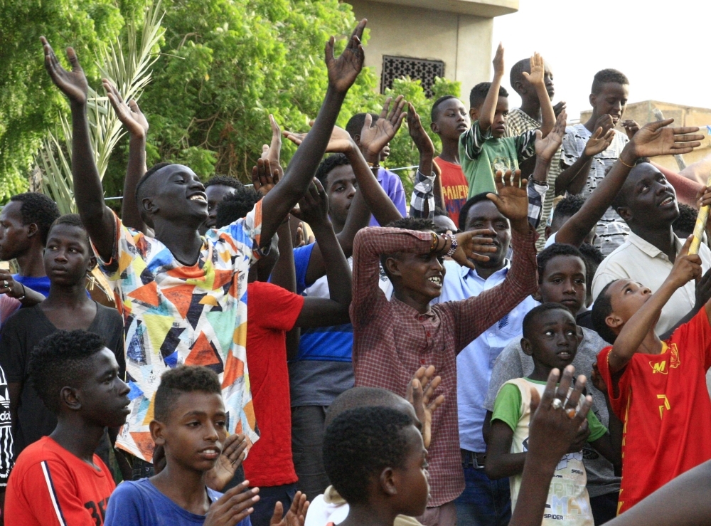 Young Sudanese men and children celebrate in the capital Khartoum, a day after generals and protest leaders signed a historic transitional constitution meant to pave the way for civilian rule in Sudan, on Sunday. -AFP