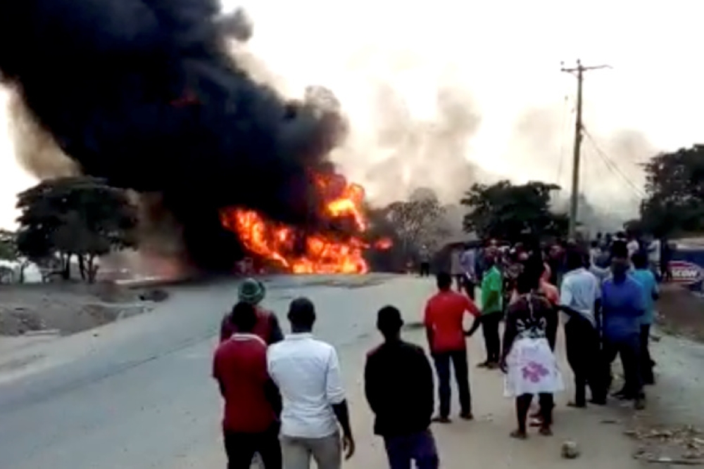 People look towardss a fire following a fuel truck collision in Rubirizi, Uganda, on Sunday in this still image taken from social media video. — Reuters