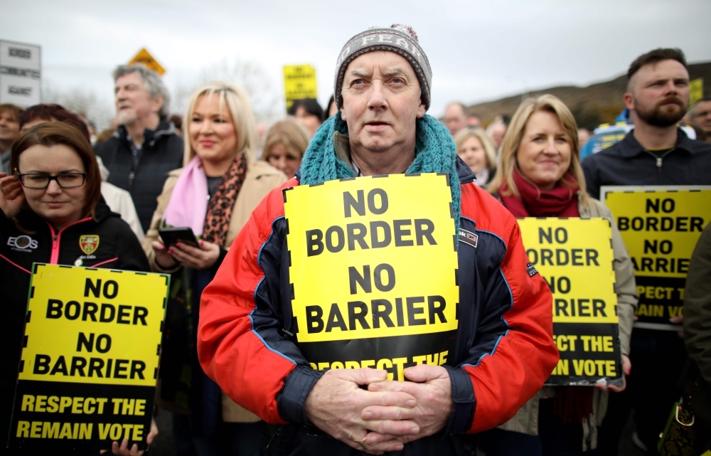 Protesters against any border between Ireland and Northern Ireland because of Brexit hold placards at the Carrickcarnan border between Newry in Norther Ireland and Dundalk in the Irish Republic in this March 30, 2019 file photo. — AFP