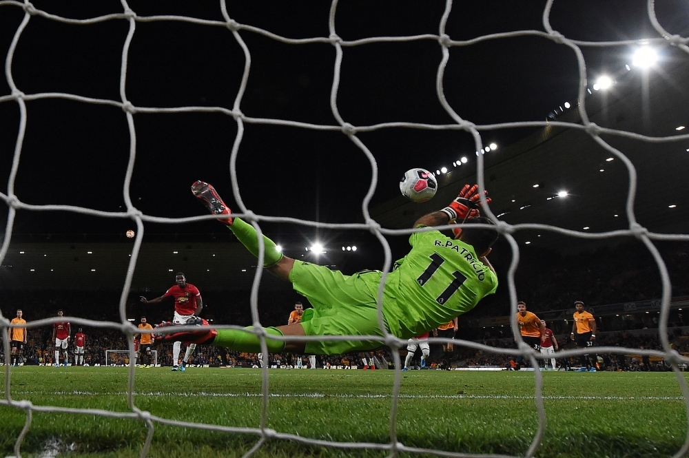 Wolverhampton Wanderers' Portuguese goalkeeper Rui Patricio (R) saves a penalty shot from Manchester United's French midfielder Paul Pogba during the English Premier League football match between Wolverhampton Wanderers and Manchester United at the Molineux stadium in Wolverhampton, central England, on Monday. — AFP