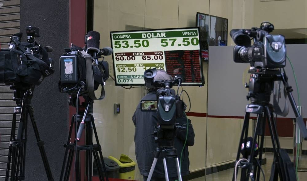 Cameras point at an exchange rate board in the financial district of Buenos Aires on August 20 after Argentina's President Mauricio Macri swore Hernan Lacunza in as the country's new economy minister. — AFP
