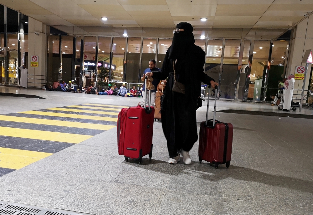 A Saudi woman walks with her luggage as she arrives at King Fahd International Airport in Dammam in this Aug. 5, 2019 file photo — Reuters