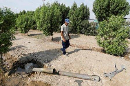 A man looks at a rocket that flew away after a weapons depot of an Iraqi militia group caught fire, in Baghdad, in this file photo. — Reuters