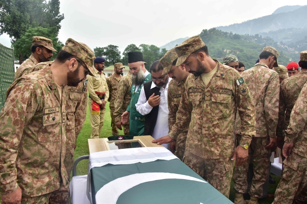Pakistani soldiers look at a colleague who was killed in cross border shelling during a funeral in Muzaffarabad, the capital of Pakistan-controlled Kashmir, in this Aug. 16, 2019 file photo. — AFP