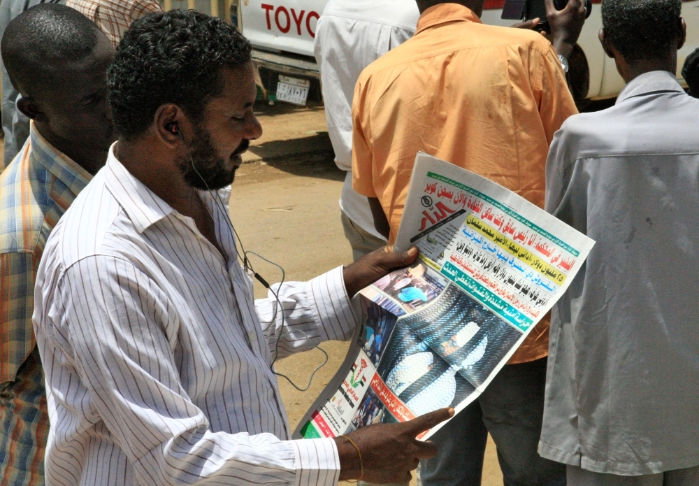 A Sudanese man reads the newspaper on August 20, 2019 headlining the court appearance of Sudan's deposed military ruler Omar al-Bashir during the opening of his corruption trial the previous day. AFP