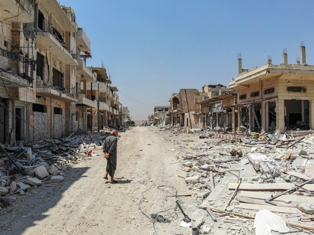 This file aerial view taken on Aug. 3, 2019 shows a Syrian man inspecting the damages in the town of Khan Sheikhun in the southern countryside of the northwestern Idlib province. — AFP