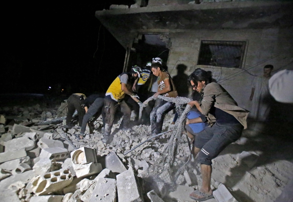 Members of the Syrian Civil Defence (White Helmets) sift through the rubble of a building following a reported government air strike in the area of Maaret Al-Numan in Syria's northwestern Idlib province on August Thursday. — AFP
