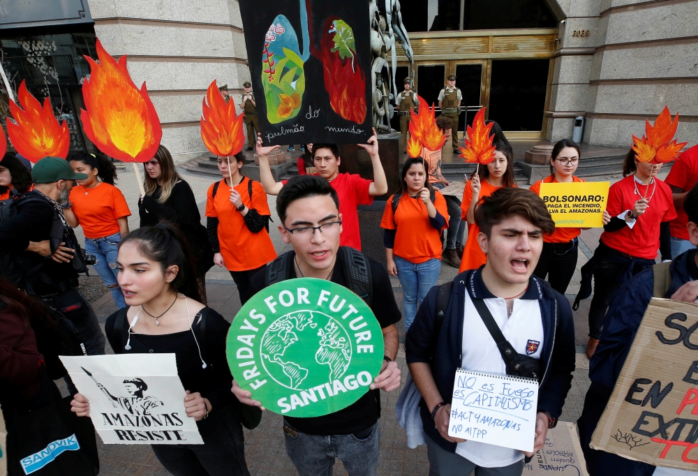 Demonstrators of environmental organizations take part in a rally in front of the embassy of Brazil in demand to more Amazon protection in Santiago, Chile on Friday. -Reuters