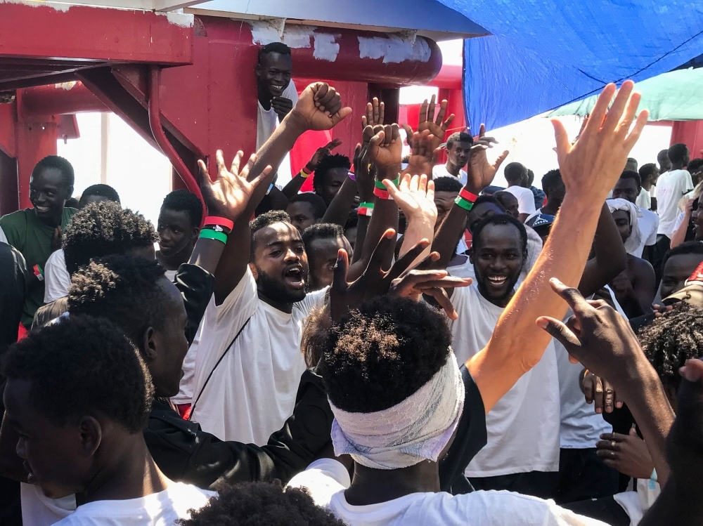 Migrants celebrate aboard the 'Ocean Viking' rescue ship, jointly operated by French NGOs SOS Mediterranee and Medecins sans Frontieres (MSF Doctors without Borders) on Friday, as six EU countries agreed to take them in after 14 days at sea. -AFP