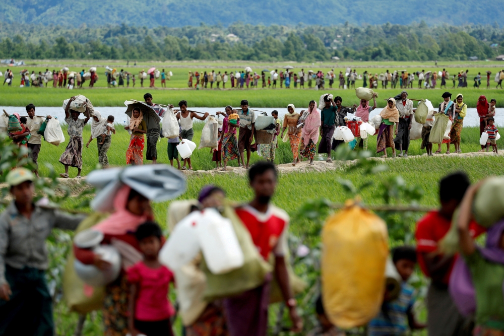  Rohingya refugees, who crossed the border from Myanmar two days before, walk after they received permission from the Bangladeshi army to continue on to the refugee camps, in Palang Khali, near Cox's Bazar, Bangladesh October 19, 2017. -Reuters