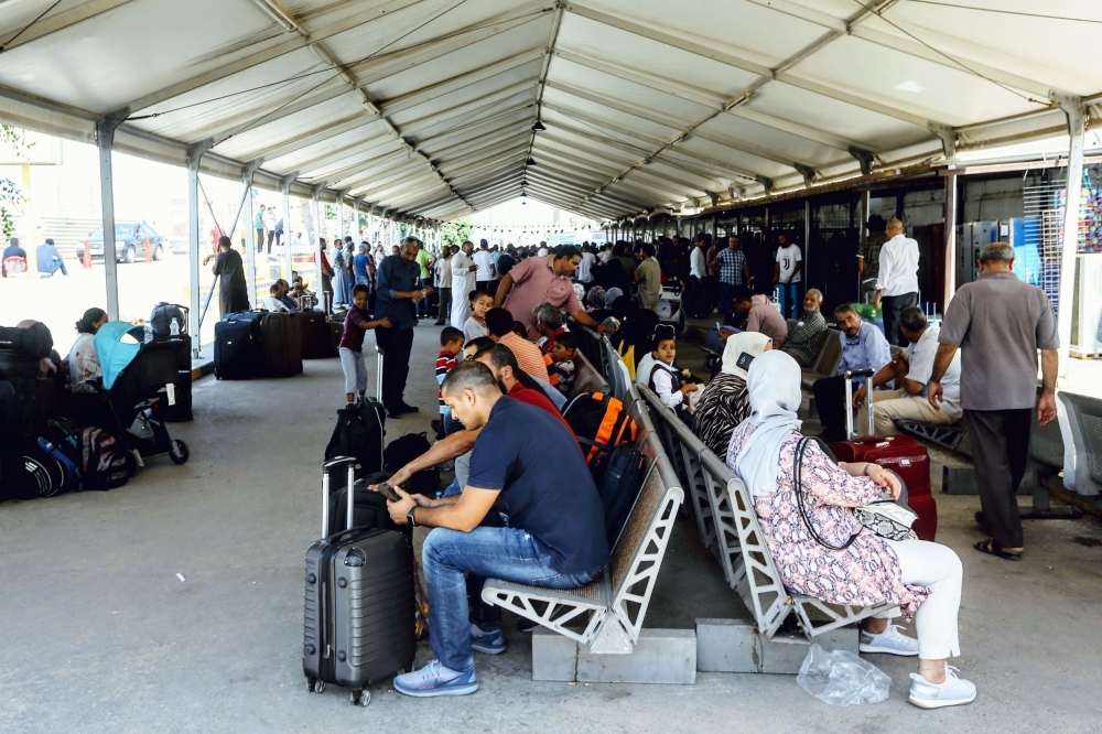 Passengers wait for their flights at Mitiga International Airport in Libya's capital Tripoli on Saturday, after a rocket hit the airport which suspended flights. — AFP
