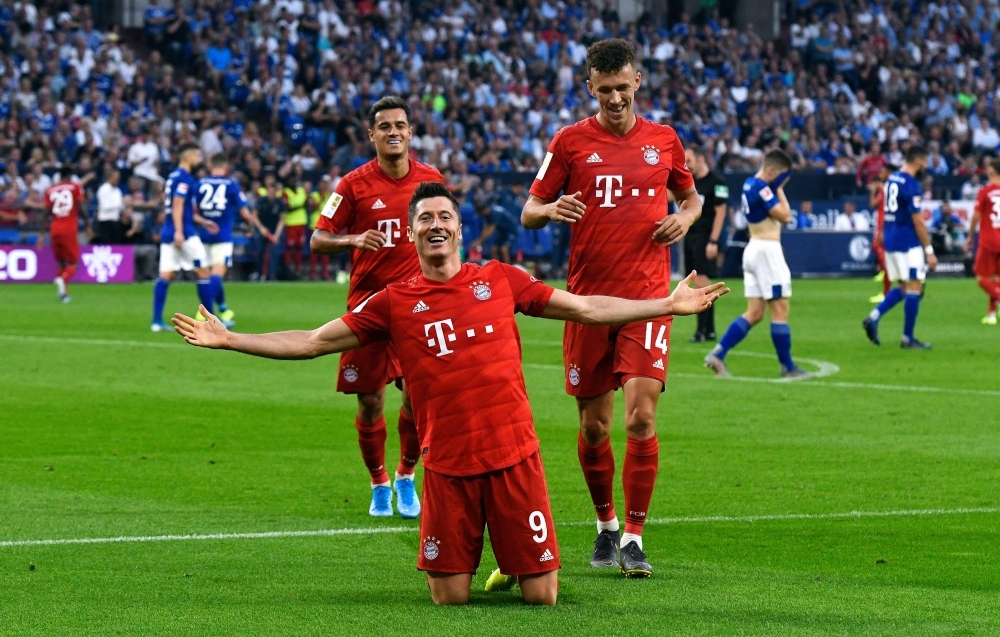 Bayern Munich's Polish forward Robert Lewandowski celebrate scoring his third goal wiht his teammates during the German first division Bundesliga football match FC Schalke 04 FC Bayern Munich in Gelsenkirchen, western Germany, on Saturday. — AFP