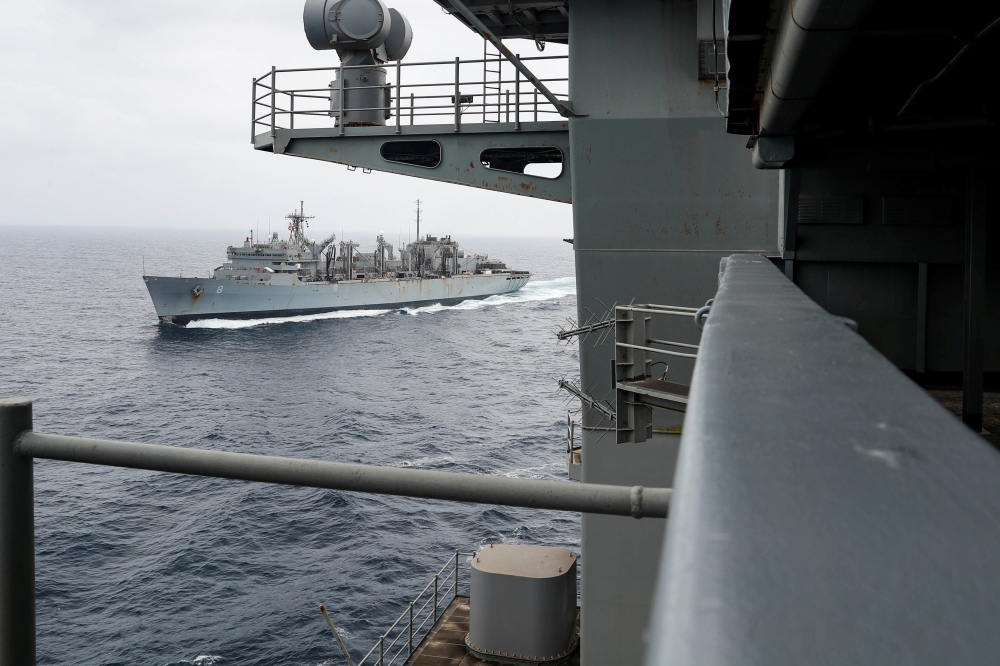 The aircraft carrier USS Abraham Lincoln (CVN 72) breaks away from the fast combat support ship USNS Arctic (T-AOE 8) after a replenishment-at-sea, in Gulf.