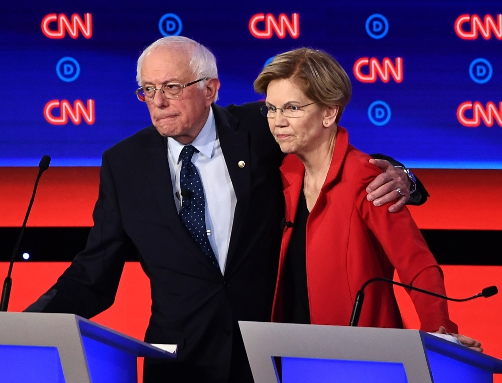  In this file photo taken on July 30, 2019 Democratic presidential hopefuls US Senator from Vermont Bernie Sanders (L) and US Senator from Massachusetts Elizabeth Warren hug after participating in the first round of the second Democratic primary debate of the 2020 presidential campaign season in Detroit, Michigan. -AFP