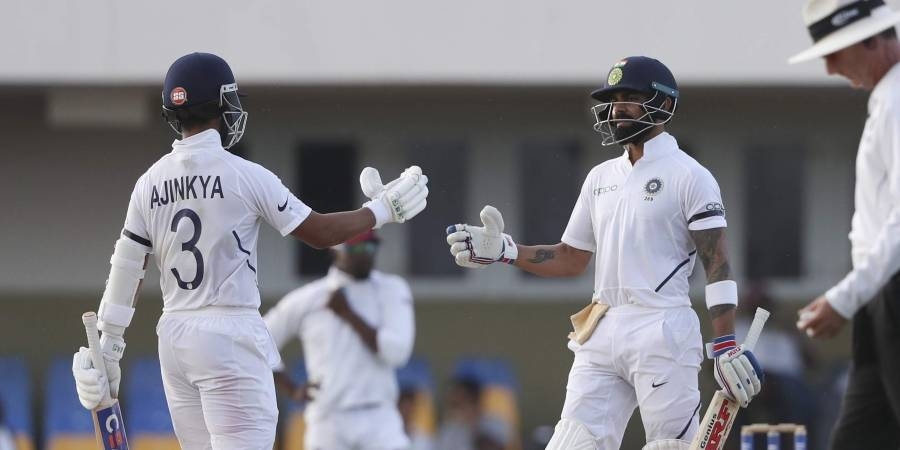 India's captain Virat Kohli, right, is greeted by teammate Ajinkya Rahane after scoring a half century against West Indies during day three of the first Test cricket match at the Sir Vivian Richards cricket ground in North Sound, Antigua and Barbuda, on Saturday. — Courtesy photo
